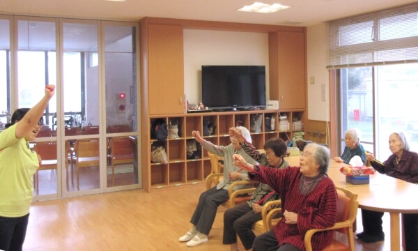 ご利用者が右手をあげ体操をする写真