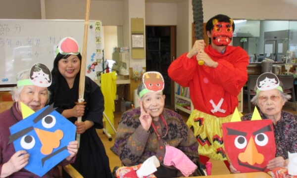 節分の仮装をするスタッフと鬼やおたふくのお面をしたご利用者の写真