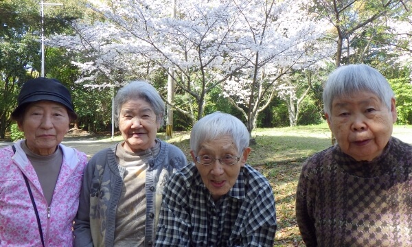 満開の桜の前に並ぶ４名のご利用者の写真