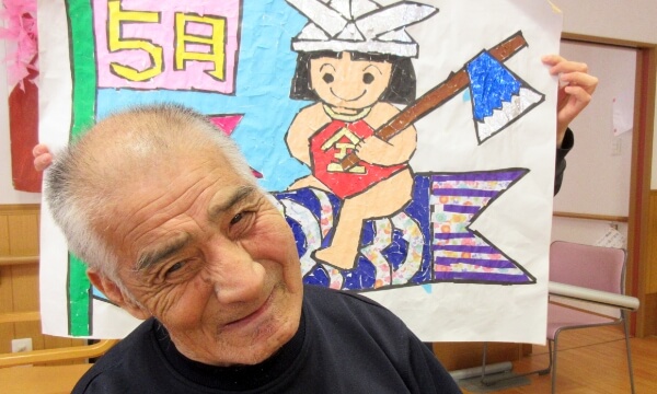 5月の絵の前にいる笑顔のご利用者の写真