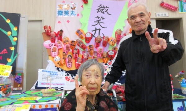 作品の前でピースサインをする２名のご利用者の写真