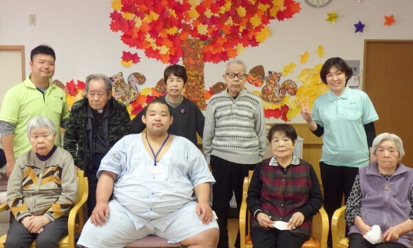 訪問した力士と並んで映るご利用者と職員の写真